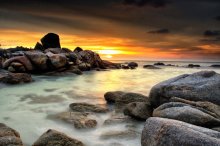 Фотообои Каменистый морской берег на фоне заката